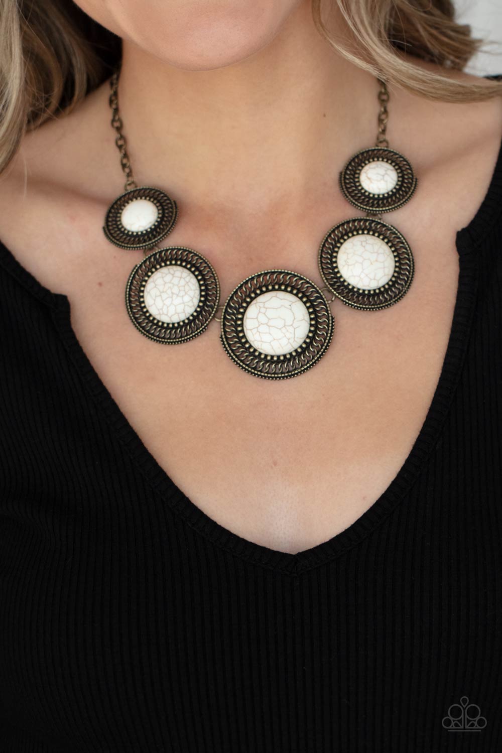 She Went West - Brass and White Stone Necklace - Paparazzi Accessories - Earthy white stones, pressed into round antiqued brass frames featuring dot and interlinking loop motifs, create a dramatically rustic statement as they link across the collar. Features an adjustable clasp closure. 