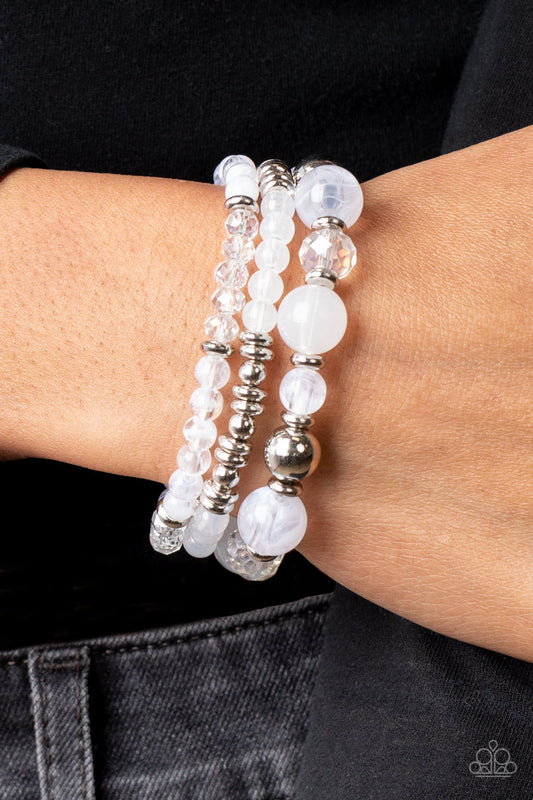 Shoreside Stroll - White and Silver Bracelets - Paparazzi Accessories - A mismatched assortment of glassy and opaque white beads joins white crystal-like and dainty silver accents along stretchy bands around the wrist, resulting in dreamy layers.  Sold as one set of three bracelets.