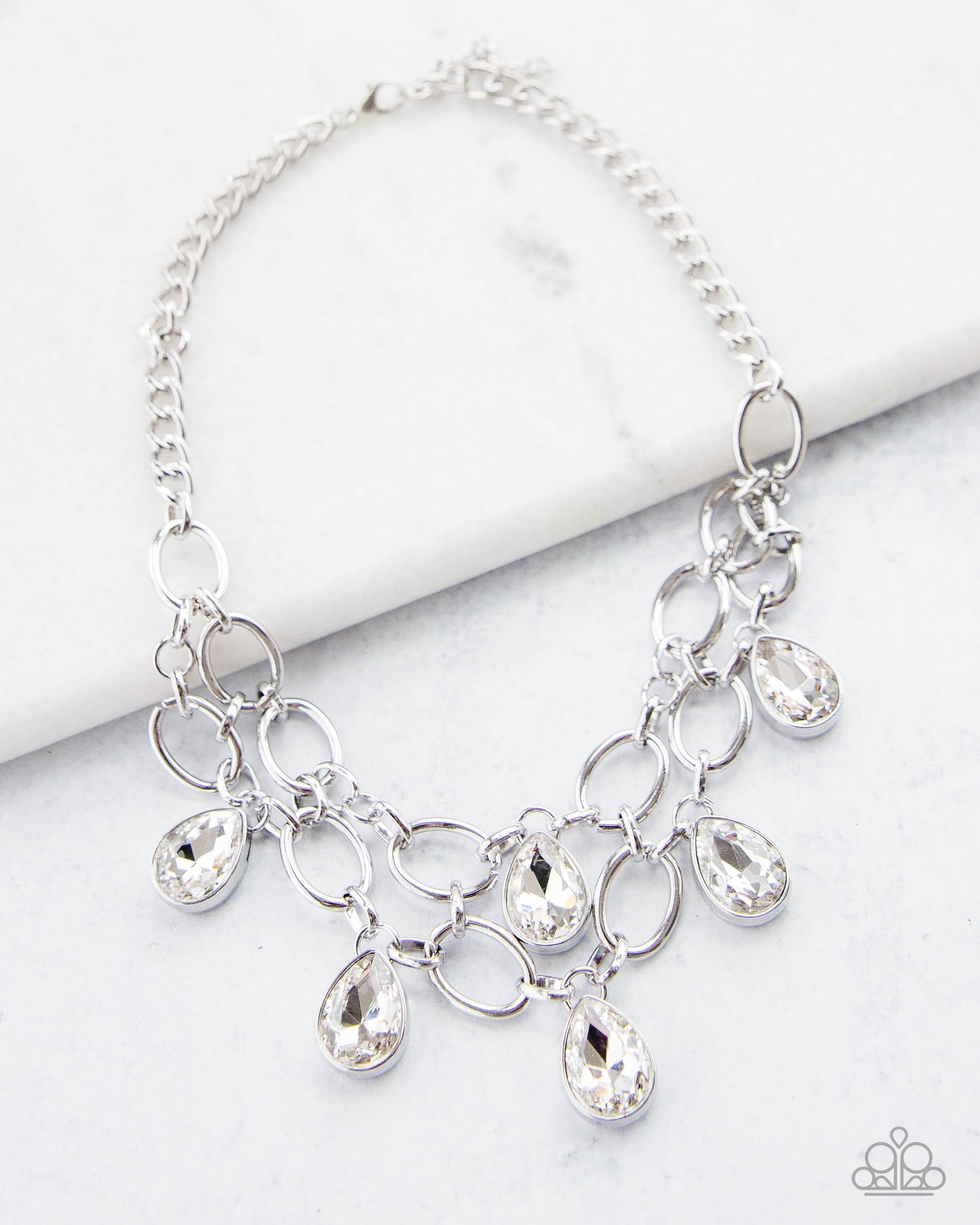 Show Stopping Shimmer - Gem Silver Fashion Necklace - Paparazzi Accessories - Fashion necklace with two rows of silver chain layer below the collar for a fierce fashion. Glittery white teardrops gems hang from the glistening layers for a timeless shimmer to the show-stopping statement style. Necklace has an adjustable clasp closure.