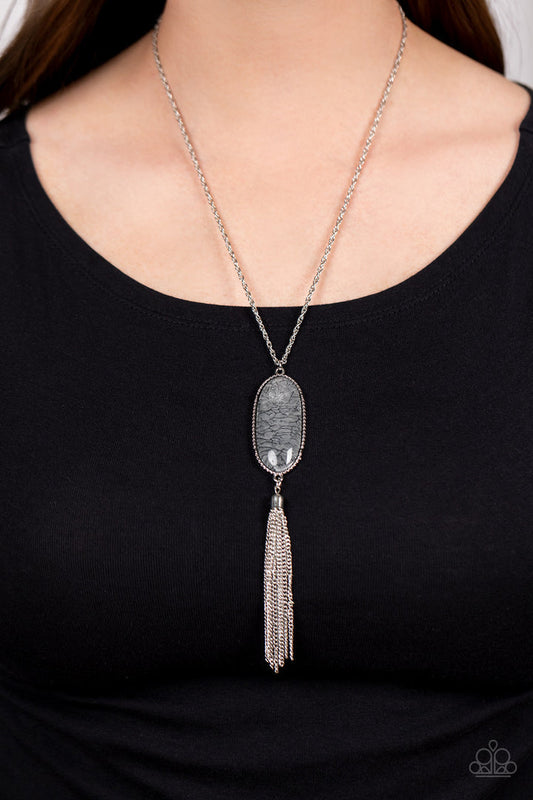 Southern Stroll - Silver Necklace - Paparazzi Accessories - Shimmery Northern Droplet lacquer-like paint swirls into a faux stone pattern inside of a glassy casing. The oblong pendant glides along a classic silver chain below the collar while a silver tassel dances from the bottom of the display, adding wanderlust movement to the whimsical piece. Features an adjustable clasp closure.
Sold as one individual necklace.