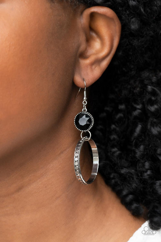 Standalone Sparkle - Black and Silver Fashion Earrings - Paparazzi Accessories - The outer edge of a silver ring is stamped with a flattened dot motif as it swings below a dramatic black rhinestone that sparkles inside a daintily dotted antiqued silver frame, creating an upscale, edgy modern lure. Earring attaches to a standard fishhook fitting. Sold as one pair of earrings.