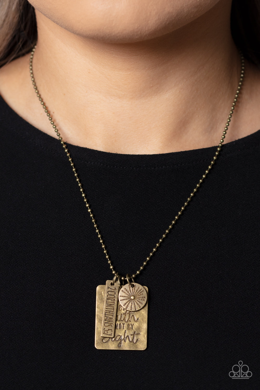 Sunshine Sight - Brass Necklace - Paparazzi Accessories - Hanging from a brass ball chain, a gritty collection of a rectangular plate dangles next to a disc featuring a sun, and a bar stamped with the Bible reference "2 Corinthians 5:7". The three dangling brass shapes add eye-catching movement to the inspired design. Prominently stamped on the rectangular pendant, the words "Walk by Faith not by Sight" stand out for a faith-filled finish. Features an adjustable clasp closure.