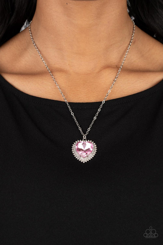 Sweethearts Stroll - Pink and Silver Necklace - Paparazzi Accessories - A pink crystal-like heart gem sparkles dramatically as it's wrapped in a glassy white rhinestone-studded heart frame. Adding additional shimmer, a second layer of white rhinestones encircles the studded pendant as it swings from a classic silver chain in a flirty finish. Features an adjustable clasp closure.