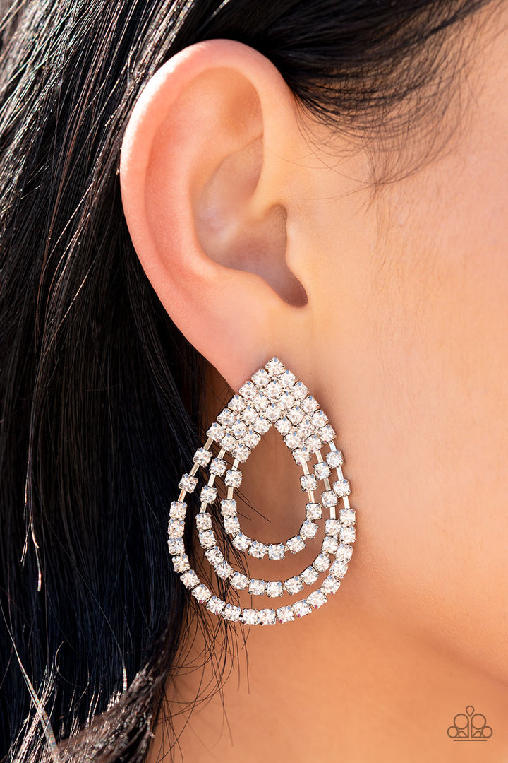 Take a POWER Stance - Silver Earrings - Paparazzi Accessories - Loops of glassy white rhinestones ripple out from the bottom of a stationary triangular fitting that is dotted in glittery white rhinestones, resulting in a timeless teardrop chandelier. Earring attaches to a standard post fitting. Sold as one pair of post earrings.