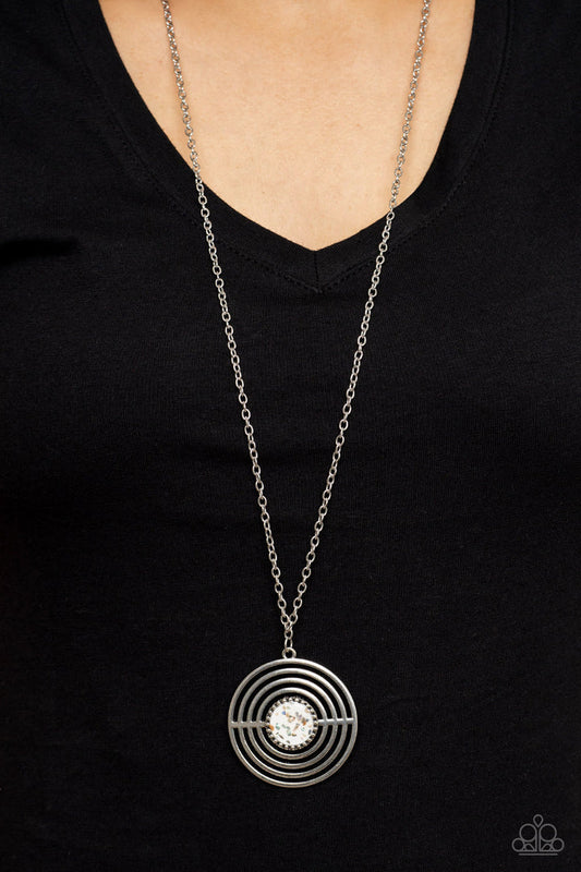 Targeted Tranquility - White and Silver Necklace - Paparazzi Accessories - Flecked in iridescent shell-like accents, a studded white frame adorns the center of an oversized silver pendant rippling with concentric circles at the bottom of an extended silver chain for a dizzying pop of color. Features an adjustable clasp closure.