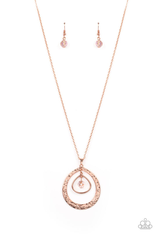 Tasteful Teardrops - Copper Necklace - Paparazzi Accessories - An iridescent peach crystal-like bead twinkles from the top of two mismatched shiny copper teardrop frames at the bottom of an extended shiny copper chain, resulting in a tasteful and timeless pendant. Features an adjustable clasp closure. Due to its prismatic palette, color may vary. Sold as one individual necklace.