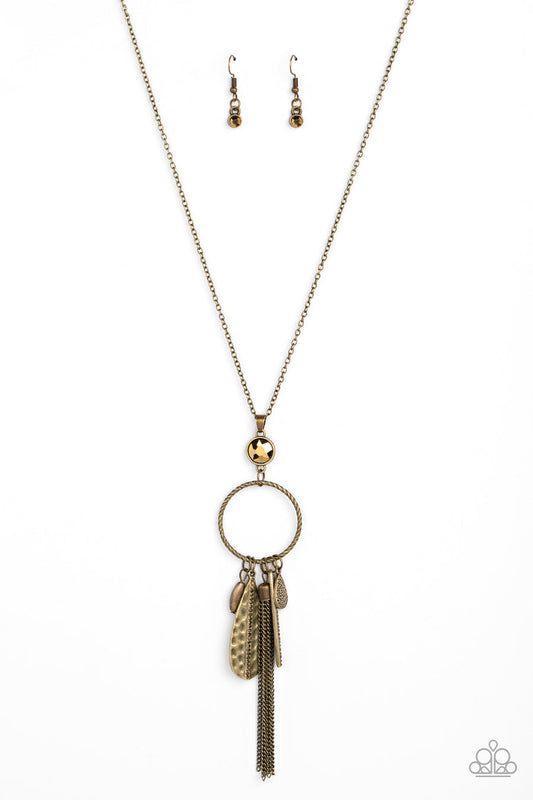 Tastefully Tasseled - Brass Necklace - Paparazzi Accessories - Featuring both smooth and hammered finishes, dainty aurum rhinestones, and a tassel of dainty chains, a sassy collection of brass charms swings from the bottom of a textured circle. A faceted aurum gem sits atop the harmoniously audacious display at the bottom of a lengthened dainty brass chain for a crowning finish.