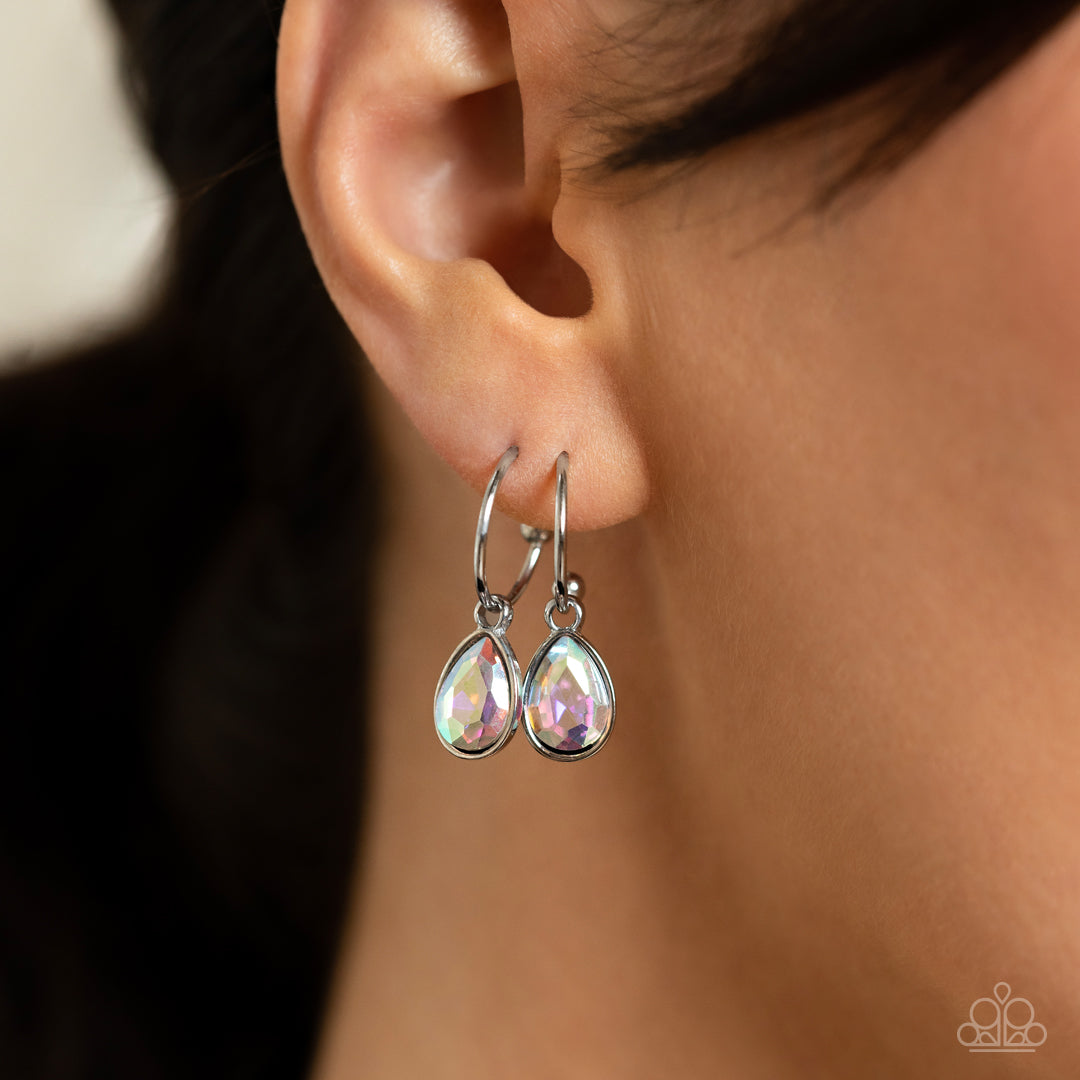 Teardrop Tassel - Multi Iridescent Earrings - Paparazzi Accessories - A small silver hoop curves around the ear in a timeless fashion. An iridescent, teardrop gem, encased in a shiny silver frame slides along the curvature of the hoop, adding a surprising hint of shimmery movement. Earring attaches to a standard post fitting. Hoop measures approximately 1/2" in diameter.