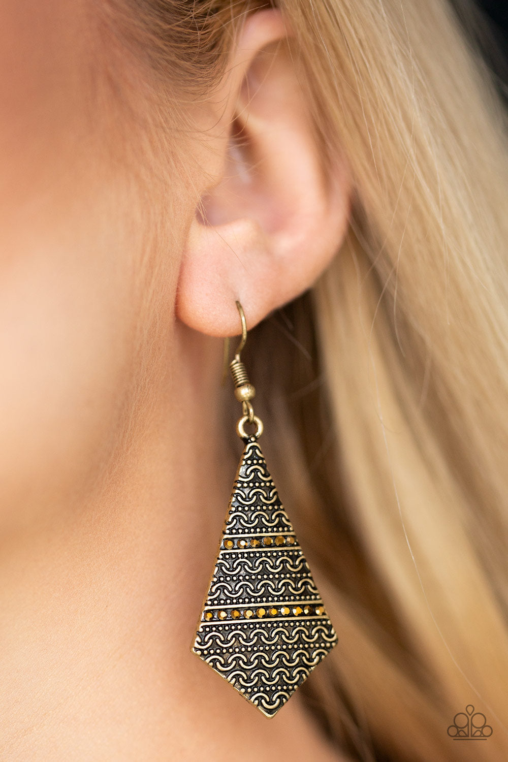 Terra Trending - Brass Fashion Earrings - Paparazzi Accessories - Radiating with tribal inspired patterns, a flared brass frame swings from the ear in an edgy fashion. Rows of dainty aurum rhinestones are pressed into the lure for a shimmery finish. Earring attaches to a standard fishhook fitting.