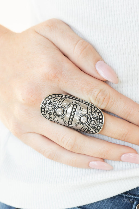 Tiki Trail - Silver Tribal Inspired Ring - Paparazzi Accessories - Studded and stamped in tribal inspired textures, an oversized silver frame folds around the finger for a rustically authentic look. Features a stretchy band for a flexible fit ring.