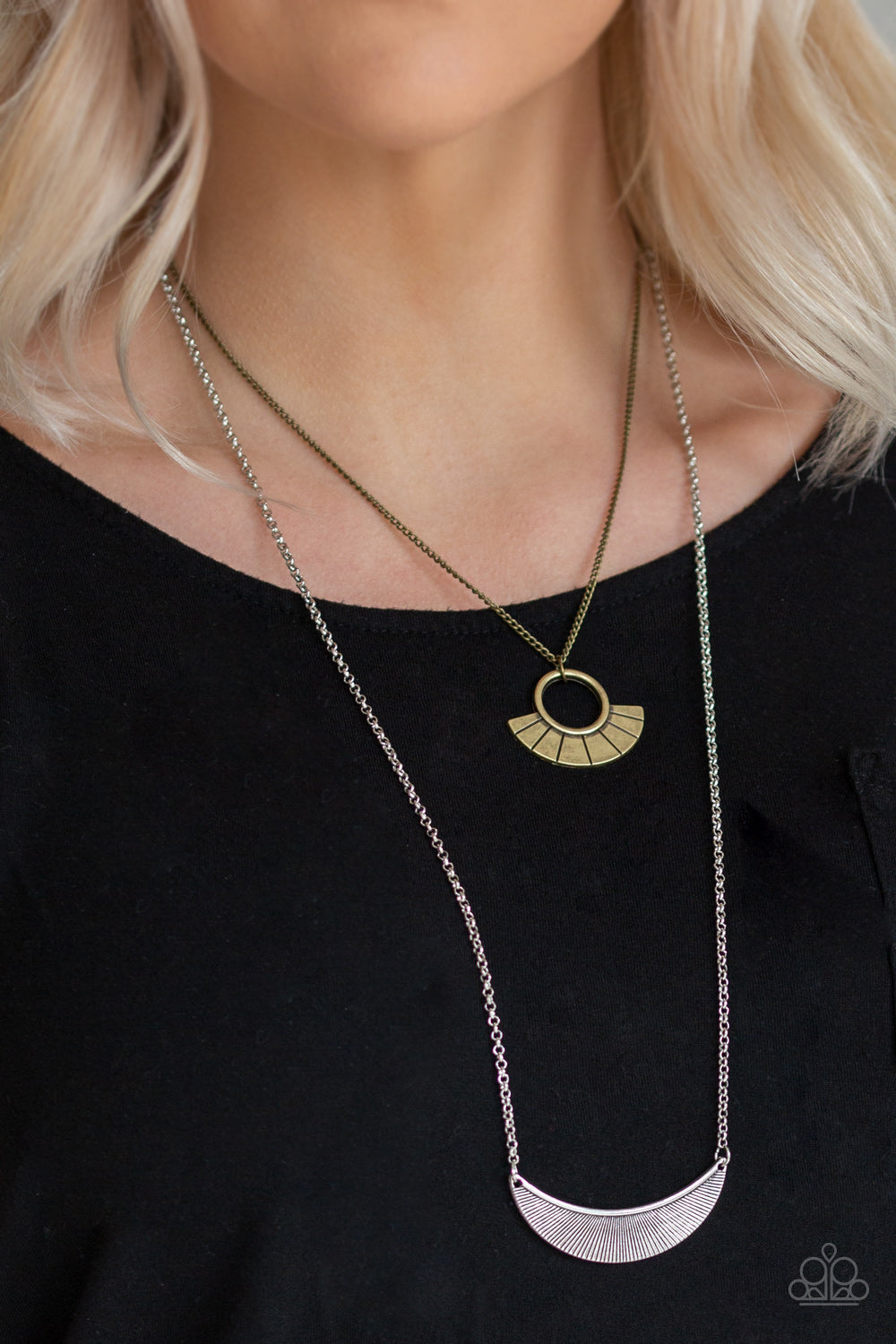 Tribal Trek - Multi Metal Necklace - Paparazzi Accessories - Brass frame swings above a silver half-moon frame, creating tribal inspired layers below the collar. Features an adjustable clasp closure.