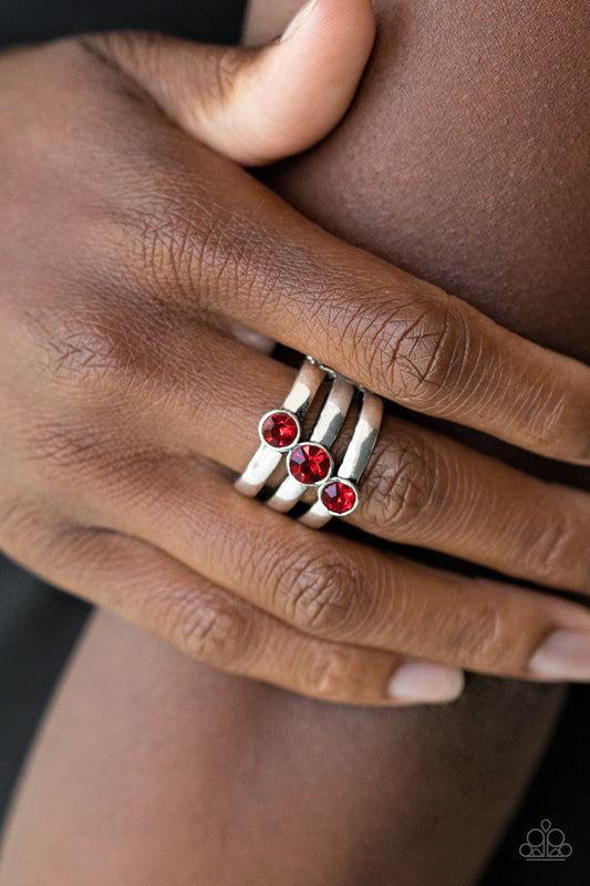 Triple The Twinkle - Red and Silver Ring - Paparazzi Accessories - A trio of red rhinestones slant across three stacked silver bands, coalescing into a refined centerpiece. Features a stretchy band for a flexible fit. Sold as one individual ring.