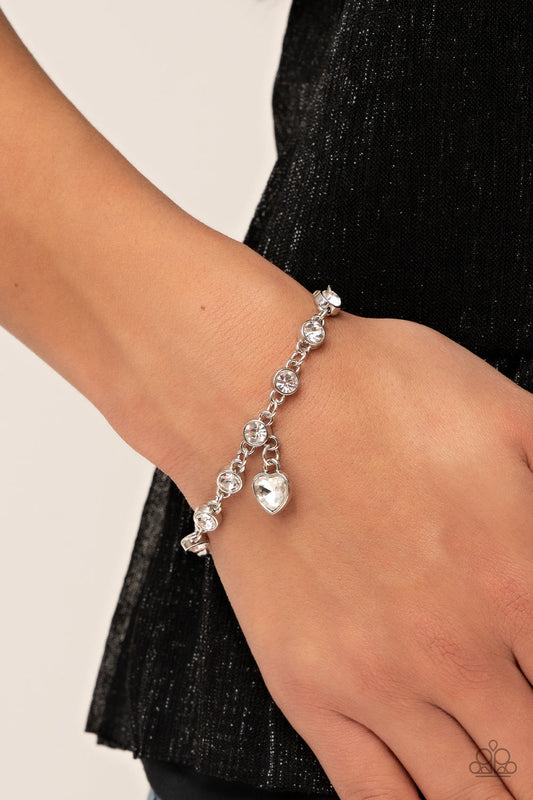 Truly Lovely - White Heart - Silver Bracelet - Paparazzi Accessories - White rhinestone heart charm dances from a strand of white rhinestones, resulting in a flirtatious sparkle around the wrist. Features an adjustable clasp closure.