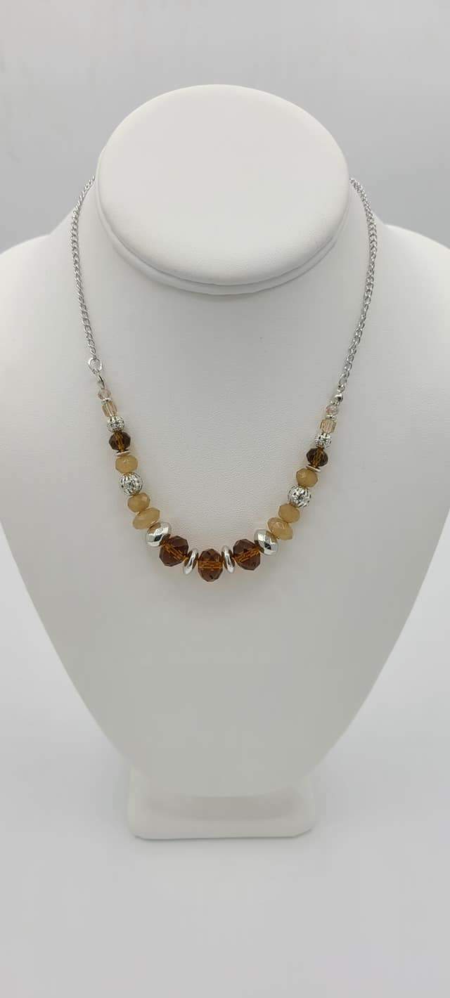 Turn Up the Tea Lights - Brown - Silver Necklace - Paparazzi Accessories - Iridescent and crystal-like beads are threaded along an invisible wire that is attached to a silver chain below the collar. Mismatched brown beads and ornate brown accents are sprinkled between the glittery compilation, adding a whimsy sheen to the colorful statement piece. Features an adjustable clasp closure. Bejeweled Accessories By Kristie - Trendy fashion jewelry for everyone -