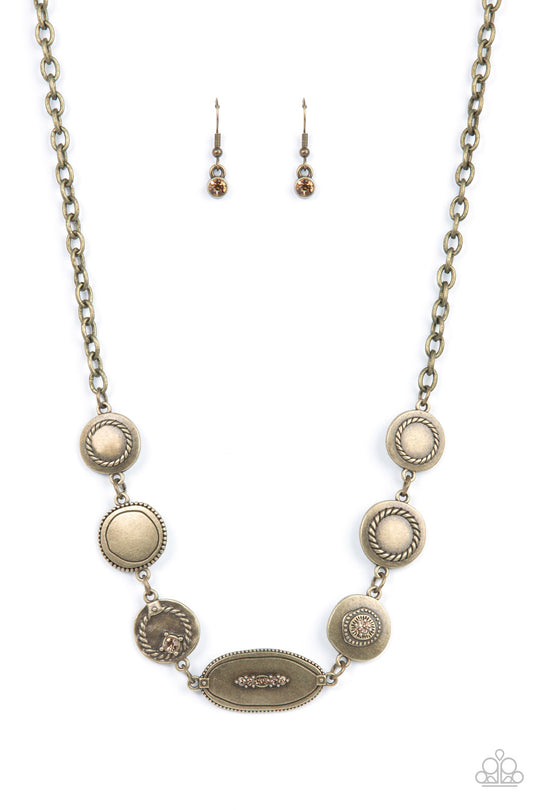 Uniquely Unconventional - Brass Necklace - Paparazzi Accessories - Sporadically dotted in dainty topaz rhinestones and metallic rope-like texture, an asymmetrical assortment of rustic brass frames delicately link below the collar for a one-of-a-kind shimmer. Features an adjustable clasp closure. Sold as one individual necklace.