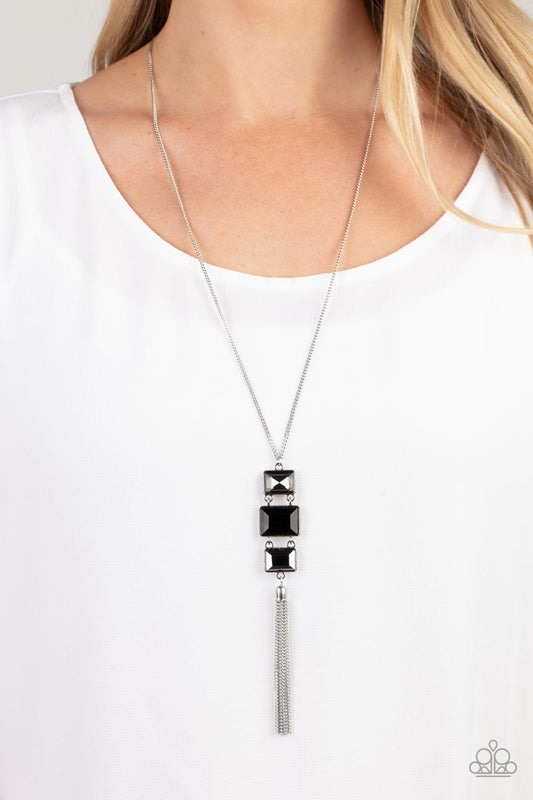 Uptown Totem - Black - Hematite - Silver Gem Necklace - Paparazzi Accessories - A sparkly collection of mismatched smoky, black, and hematite rectangular gems stack at the bottom of a lengthened silver chain, creating a glamorous pendant. A dainty silver chain tassel swings from the bottom, adding glamorous movement to the modern display.