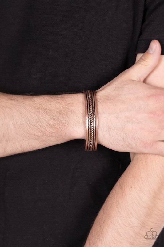Urban Expedition - Copper Men's Urban Bracelet - Paparazzi Accessories - The center of a rustic copper cuff is embossed in metallic rope-like texture, creating a tribal inspired centerpiece around the wrist. Sold as one individual bracelet.