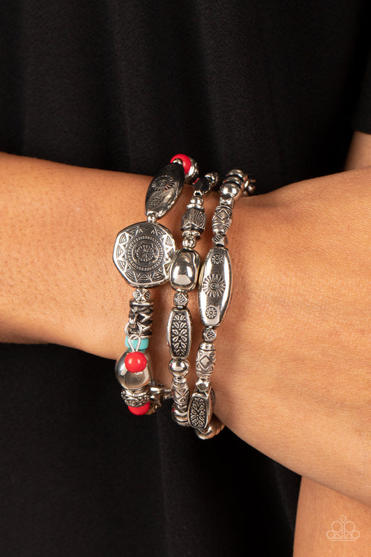Western Quest - Red and Turquoise Bracelet - Paparazzi Accessories - Hints of red and turquoise accents, a mismatched collection of silver beads, textured silver accents, and floral and sunburst embossed beads are threaded along stretchy bands around the wrist.