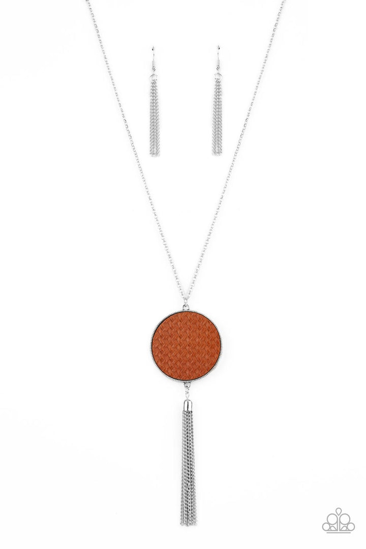 Wondrously Woven - Brown Leather - Silver Necklace - Paparazzi Accessories - Featuring a faux woven finish, a shiny piece of Adobe leather is pressed into a studded circular frame at the bottom of a lengthened silver chain. Capped in a frame, a silver chain tassel streams out from the colorful pendant for a playful finish. Features an adjustable clasp closure.